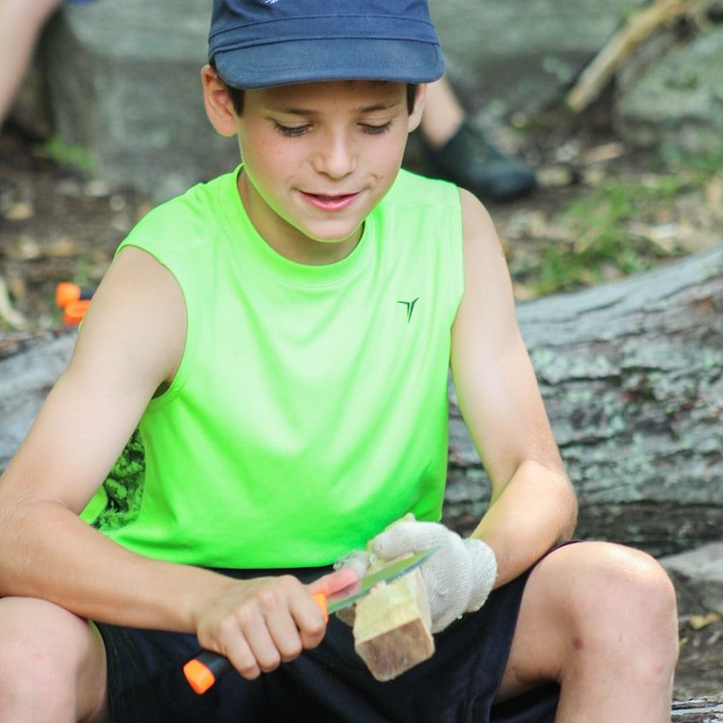 boy in green shirt whittling